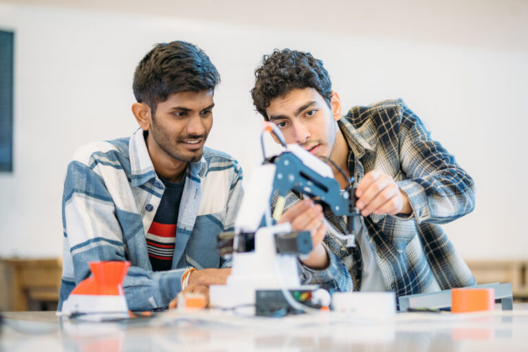 Students working on a robotic arm Dobot